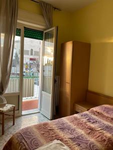 a bedroom with a bed and a sliding glass door at Albergo pensione Bianco in San Giovanni Rotondo