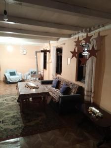 Shuakhevi的住宿－Guest House Dedeshvilebi，客厅配有沙发,墙上挂着星星。