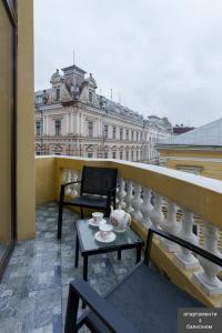 a balcony with a table and a chair and a building at Apart hotel на Франка in Chernivtsi
