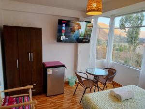 um quarto com uma mesa e uma televisão na parede em Casa Yanahuara Valle Sagrado - Urubamba em Urubamba