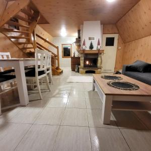 a living room with a couch and a table and a fireplace at Domki Bieszczady Siedlisko Harenda in Czarna