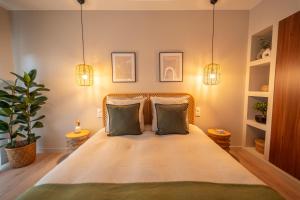 um quarto com uma cama grande e 2 almofadas em LE NID, superbe chambre d'hôtes em Mauves-sur-Loire