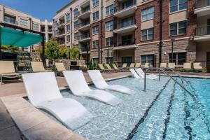a swimming pool with chairs and a building at League Flats Uptown at West Trade Street in Charlotte