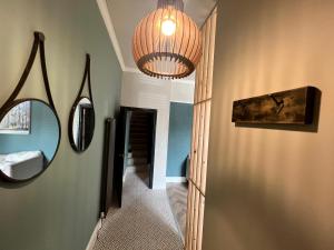 a hallway with a mirror and a chandelier at Lancaster Place 20 in Carnforth