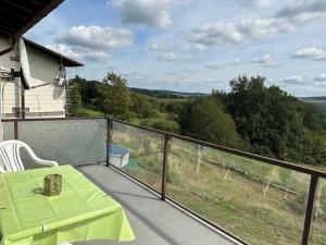 balcón con mesa verde y vistas al campo en Ferienwohnung Varuswald, en Tholey