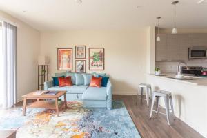 a living room with a blue couch and a table at League Flats Uptown at West Trade Street in Charlotte