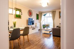 un soggiorno con tavolo, sedie e divano di BoRa Apartments a Villach