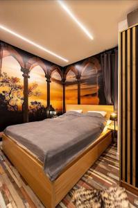una camera da letto con un letto e un dipinto sul muro di Friday’s apartman a Debrecen