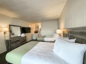 um quarto de hotel com duas camas e um espelho em The Grand Regal Resort em Elizabethtown
