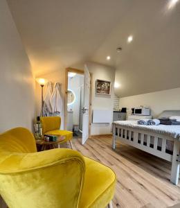 a bedroom with a bed and a yellow chair at Speir dorcha cabin in Omagh
