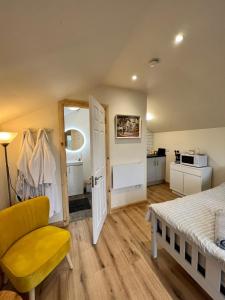 1 dormitorio con 1 cama y 1 silla amarilla en Speir dorcha cabin, en Omagh