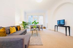 a living room with a couch and a table at Spacious & Charming garden flat -Zone 2- Great for Central London access in London