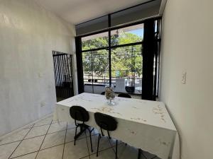 a room with a table with chairs and a large window at Loft São João Exclusive in São João da Boa Vista