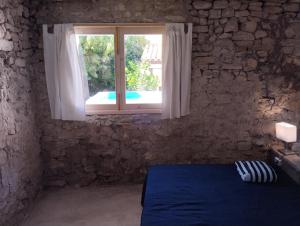 ein Schlafzimmer mit einem blauen Bett und einem Fenster in der Unterkunft Can Polta in Santa Margalida