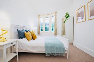 a white bedroom with a bed and a window at Spacious & Charming garden flat -Zone 2- Great for Central London access in London