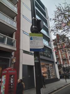 a street light with a phone booth on a street at Chic Flat in Oxford Circus in London