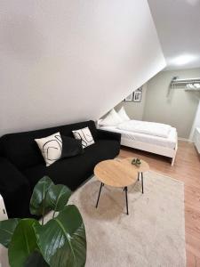 ein Wohnzimmer mit einem schwarzen Sofa und einem Tisch in der Unterkunft NAMI - ROBIN - Helle Apartments mitten in der Stadt in Memmingen