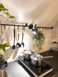 a kitchen stove with pots and pans and utensils at NAMI - ROBIN - Helle Apartments mitten in der Stadt in Memmingen