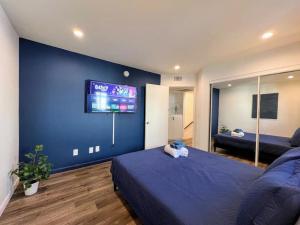 a bedroom with a blue wall with a tv on it at Trendy 2BR Near Hollywood Hotspots - BR9 in Los Angeles