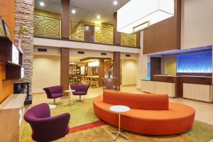a lobby with a couch and purple chairs at Fairfield Inn and Suites Chicago Lombard in Lombard