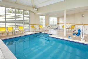a swimming pool with yellow chairs and a pool slide at Fairfield Inn and Suites Chicago Lombard in Lombard