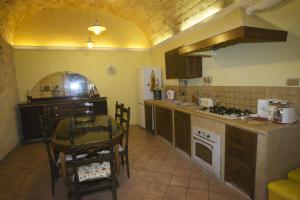 タルクイーニアにあるLa Casa di Mammaのテーブル付きのキッチン、テーブルと椅子付きのキッチン