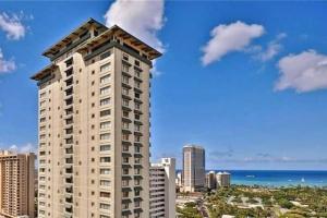 a tall building in front of the ocean at Brooks Beach Vacations Wyndham 4 Star Resort 1805 Waikiki in Honolulu