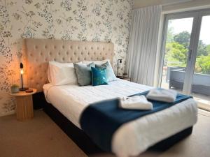 a bedroom with a bed with two towels on it at Longitude Apartments Raglan in Raglan