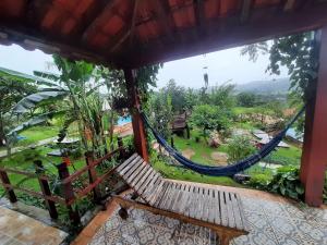 a porch with a hammock and a view of a garden at Pousada Residência Balestra in Tiradentes