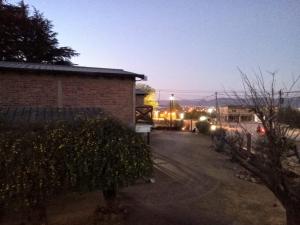 une rue la nuit avec un bâtiment et une clôture dans l'établissement CABAÑAS DE MORA, à Villa Santa Cruz del Lago