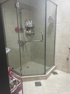a shower with a glass door in a bathroom at One bedroom apartment in Jimi in Al Ain