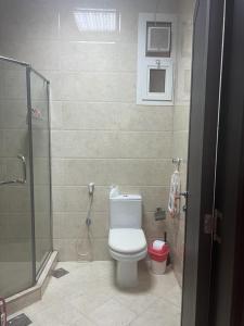 a bathroom with a toilet and a glass shower at One bedroom apartment in Jimi in Al Ain