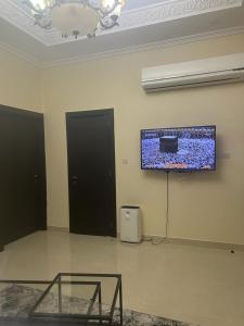 a room with a flat screen tv on the wall at One bedroom apartment in Jimi in Al Ain