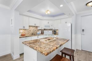 a kitchen with white cabinets and a marble counter top at Welcome to Beach Villa's # 405 Vacation Rental - 250 Estero Blvd condo in Fort Myers Beach