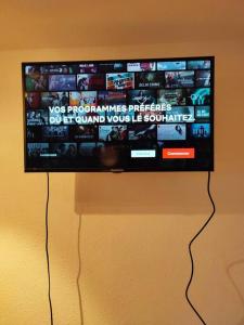 a flat screen tv hanging on a wall at L'Escapade : Charmant T2 -Parking gratuit, piscine, wifi, clim in Gruissan