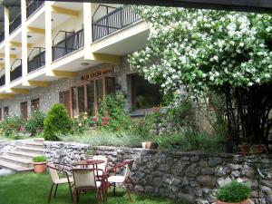 a group of chairs and tables in front of a building at Valia Calda Hotel in Perivoli