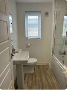 ein Bad mit einem Waschbecken, einem WC und einer Dusche in der Unterkunft Cobbeydale room in Silsden