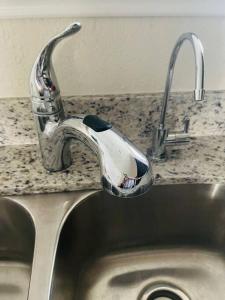 a sink with a faucet on a granite counter top at New House family friendly near Six Flags Sea World in Helotes