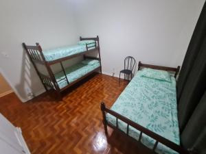 1 dormitorio con 2 literas y suelo de madera en Quartos centro de londrina Ar condicionado, en Londrina