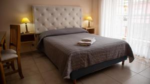 1 dormitorio con 1 cama con manta y ventana en Departamentos Sol y Arena en San Clemente del Tuyú