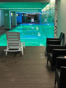 - une piscine avec une chaise blanche dans un bâtiment dans l'établissement konforun adresi, à Istanbul