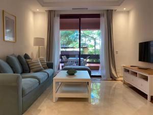 a living room with a blue couch and a table at Don Carlos Marbella Beach in Marbella