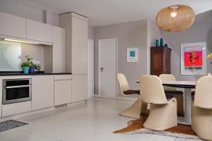 uma cozinha com armários brancos e uma mesa e cadeiras em Captain's Lounge - Bungalow XL em Westerland