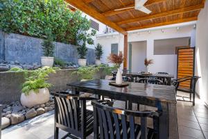 un patio con tavolo, sedie e piante di 4 You Hotel Nosara a Playa Guiones