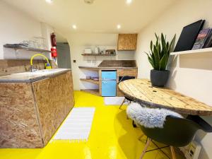 a kitchen with a table and a yellow floor at Fern Studio 1 Bedroom Apartment in Llangollen