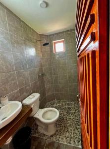 a bathroom with a toilet and a sink at Casa Guiba 3 Puerto Escondido in Puerto Escondido