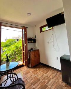 sala de estar con mesa, TV y ventana en Casa Guiba 3 Puerto Escondido, en Puerto Escondido