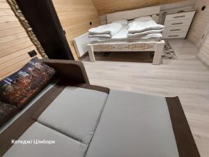 ein Zimmer mit einem Sofa und einem Tisch mit Handtüchern in der Unterkunft Котеджі Цімбори in Jablunyzja