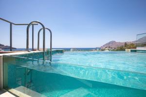 a large swimming pool with blue water at Aléa Villa Plakias in Plakias