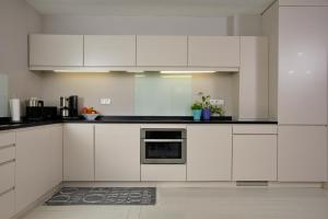 a white kitchen with white cabinets and appliances at Captain's Lounge - Bungalow XL in Westerland